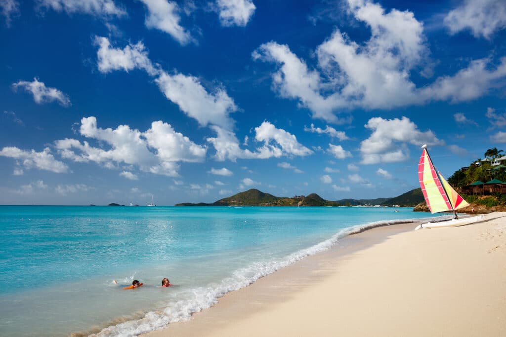 a beach with people swimming in the water